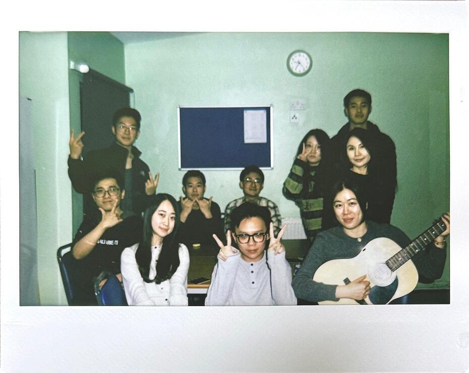A Polaroid photo of a group of students posing for the camera in a student accommodation room