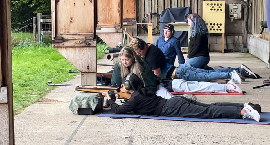 Several students practicing shooting rifles