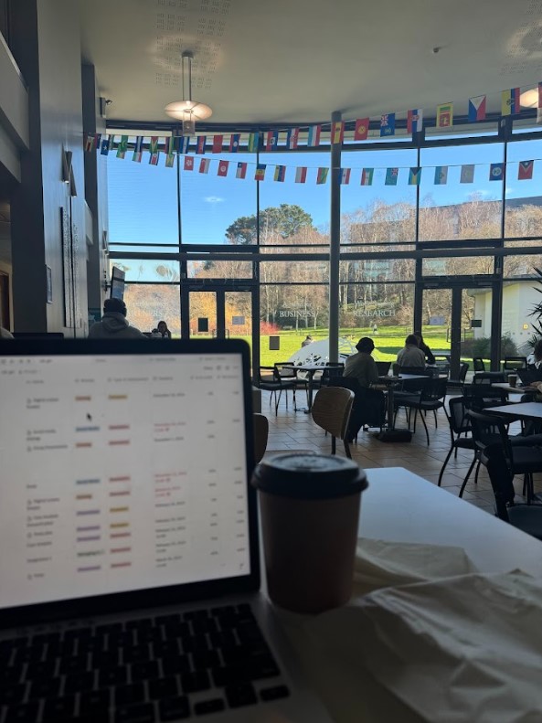 Laptop on a table in a study space with large windows